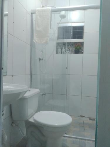 a white bathroom with a toilet and a sink at Apto 10 preço acessível in Brasília