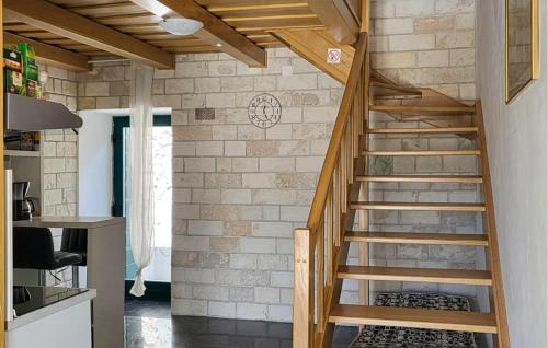 a wooden staircase in a room with a brick wall at 1 Bedroom Nice Home In Tisno in Tisno