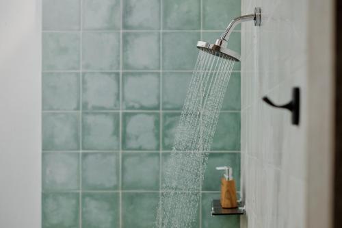 a shower with a stream of water in a bathroom at Uddhara Ubud Villa in Ubud