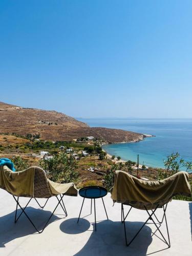 two chairs and a table on a balcony overlooking the ocean at Infinity View Villa Agios Ioannis Serifos in Serifos Chora