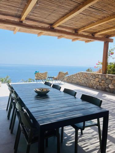 a blue table and chairs on a patio with the ocean at Infinity View Villa Agios Ioannis Serifos in Serifos Chora