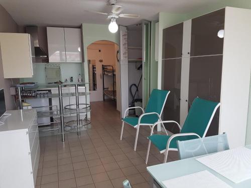- une cuisine avec des chaises vertes et une table dans une pièce dans l'établissement Studio spacieux à Sète avec parking privé, terrasse et cuisine équipée - FR-1-472-198, à Sète