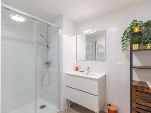 une salle de bain blanche avec une douche et un lavabo dans l'établissement Appartement T3, terrasse, parking, animaux acceptés, proche télécabine et centre de Cauterets - FR-1-401-305, à Cauterets