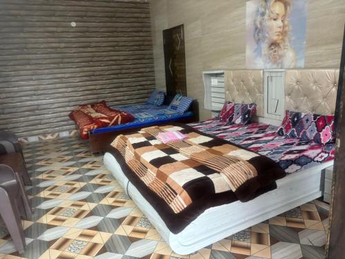 a bedroom with two beds and a painting on the wall at Magic View Guest House in Kasauli