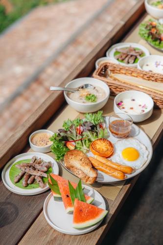 une table en bois avec des assiettes de nourriture dessus dans l'établissement Panora Doichang, à Ban San Pu Loei