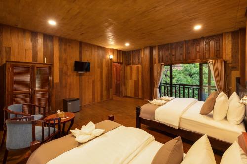 a hotel room with two beds and a balcony at Tiny Home in Phumi Ta Phul