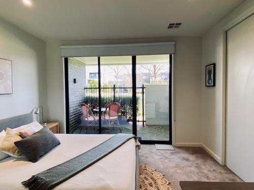 a bedroom with a bed and a balcony at Golf Sandbelt Private Room with Ensuite inc Breakfast in Cheltenham