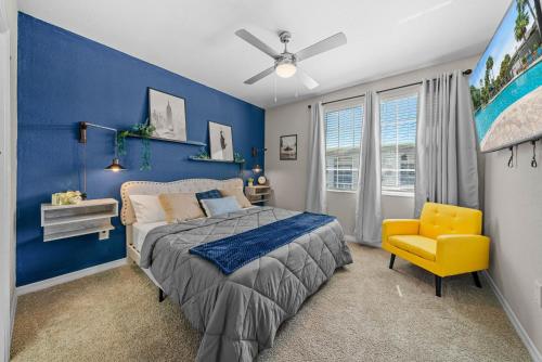 a blue bedroom with a bed and a yellow chair at Stylish 2br2ba W Pool, Gym Near Airport #3 in Tampa