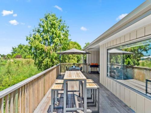a deck with picnic tables and umbrellas at Fantail Haven in Kinloch