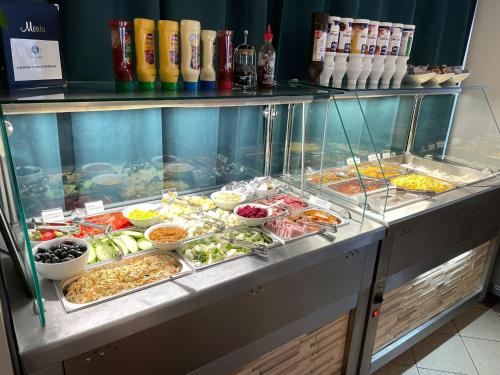 a buffet with many different types of food on display at Long Street Hotel in Braşov