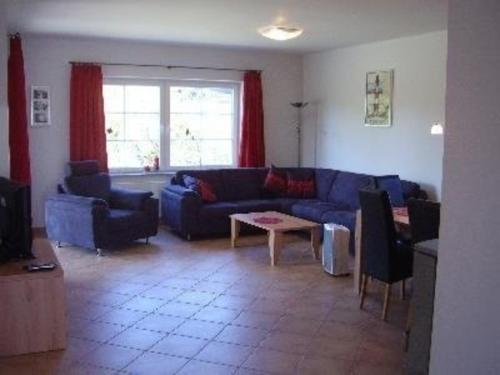 un salon avec un canapé bleu et une table dans l'établissement Bungalow Meeresbrise mit WLAN, à Butjadingen