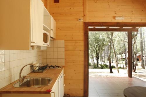 a kitchen with a sink in a wooden house at Camping Maçanet de Cabrenys in Maçanet de Cabrenys