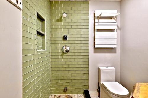 a bathroom with a shower with green subway tiles at Beartopia- Hot Tub, Views, 2 Primary Suites! in Killington