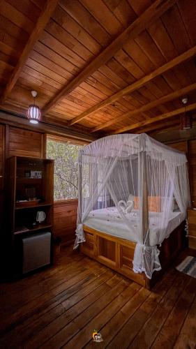 a bedroom with a bed with a mosquito net at Habarana Tree House Ambasewana Resort in Habarana