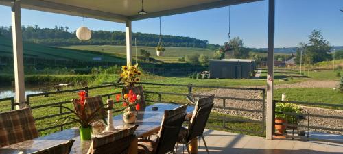 a porch with a table with flowers and a fence at Lacurile IRION in Hoghilag