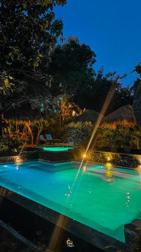 a pool at night with lights in a resort at Habarana Tree House Ambasewana Resort in Habarana