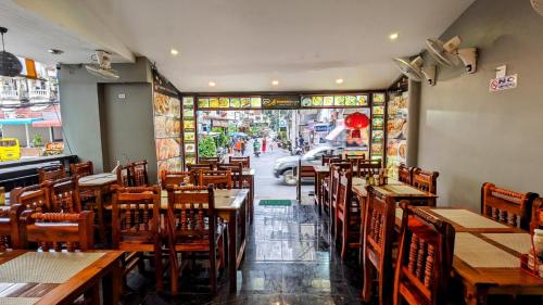 a restaurant with wooden tables and chairs and a street at Heaven House Restro & Bar in Patong Beach