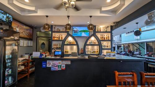 a bar in a restaurant with two arched windows at Heaven House Restro & Bar in Patong Beach