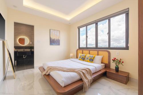 a bedroom with a bed and a large window at Thé Villa in Da Lat