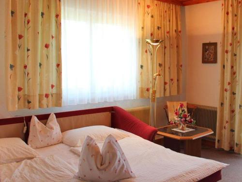 ein Hotelzimmer mit einem Bett und einem Fenster in der Unterkunft Haus Bärnthaler in Faak am See