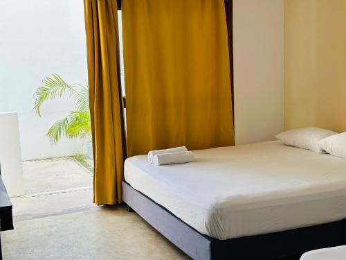 a bedroom with a bed and a window with a palm tree at Casa Coral Pueblito - Self Check In in Mahahual