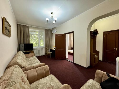 a living room with a couch and a television at Hotel Zhambyl in Taraz