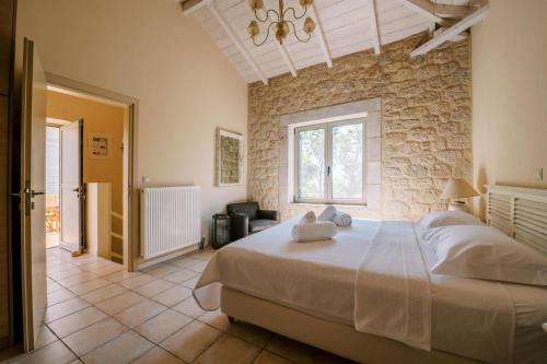 a bedroom with a large bed and a stone wall at Riglia Villas in Riglia