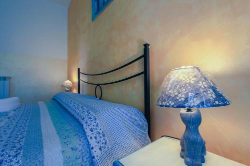 a blue lamp sitting on a table next to a bed at Villamir B&B in Albenga