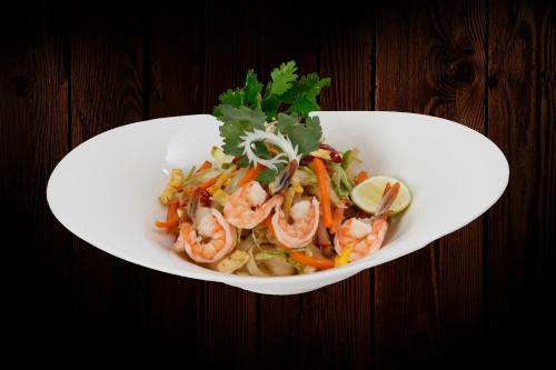 a white plate of food with shrimp and vegetables at Nagarjun Resort - Embrace Tranquility Natures Retreat Beyond the City in Kathmandu