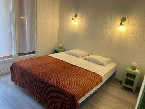 une chambre avec un grand lit avec deux tables de nuit dans l'établissement Appartement Le Panoramic - Terrasse et Parking, à Cassis