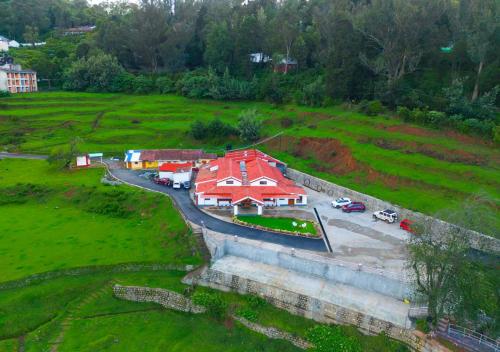 an aerial view of a building in a field at Lauriston Ooty Town Heritage Bungalow by VOYE HOMES in Ooty