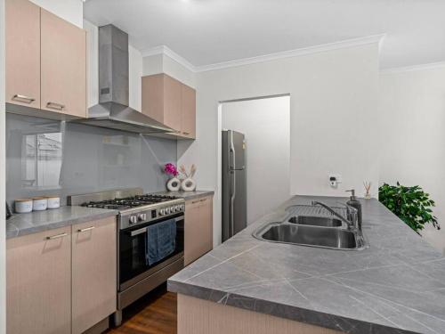 a kitchen with a sink and a stove at Popular Villa Shepparton in Shepparton