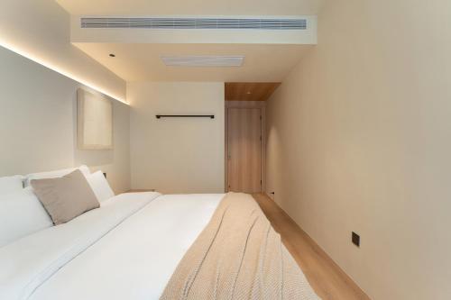 a bedroom with a large white bed and a ceiling at Miss Autumn House in Yangshuo