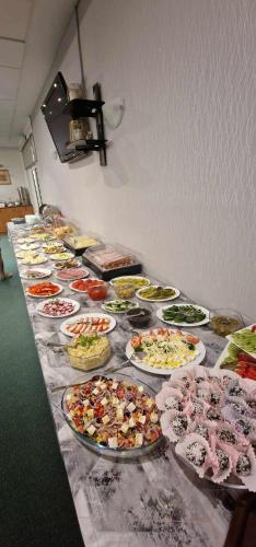 a buffet with many plates of food on a table at Willa Jarzębina in Duszniki Zdrój