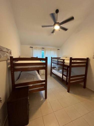 a room with two bunk beds and a ceiling fan at Villa Metro country Club in Juan Dolio