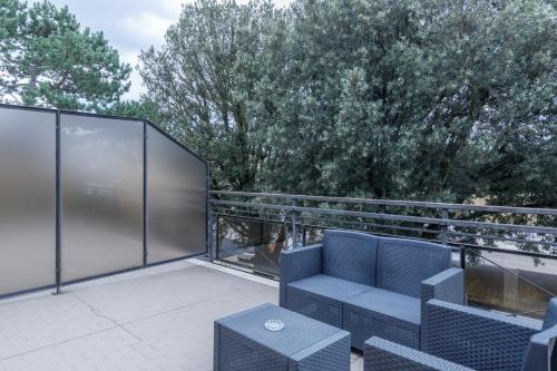 a patio with a couch and chairs on a balcony at Hotel Classicano in Ravenna