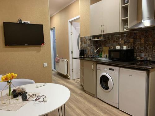 a kitchen with a washing machine and a table at Beautiful Tbilisi on Meskhishvili Turn in Tbilisi City