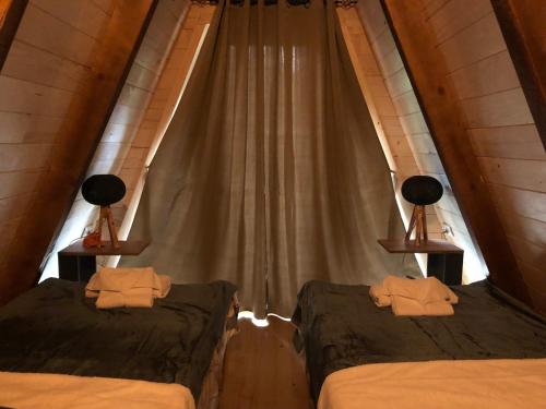 two beds in a room with a curtain at Vikendica Aleksandra in Žabljak
