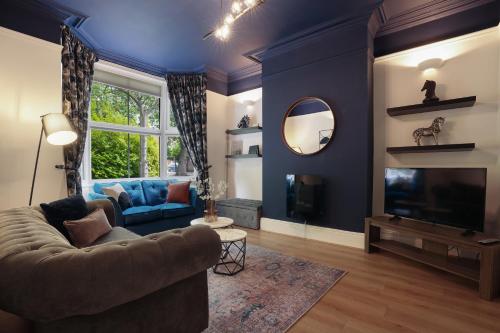 a living room with a couch and a tv and a mirror at 3 bed city centre, FREE parking, Contractors, Long Stays in Doncaster