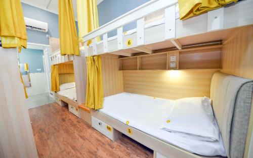 two bunk beds in a room with yellow curtains at 笑脸里青年旅舍锦里店 in Chengdu