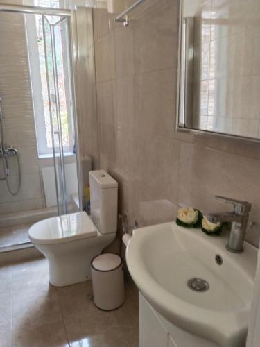 a white bathroom with a toilet and a sink at 1920 Classic in Kalamata