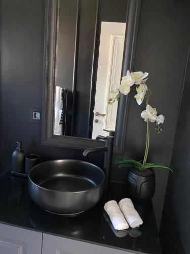 a black bathroom with a sink and a mirror at Vila Safra in Vrnjačka Banja