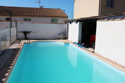 une grande piscine bleue devant un immeuble dans l'établissement studio très près d'Arles et au calme, à Arles