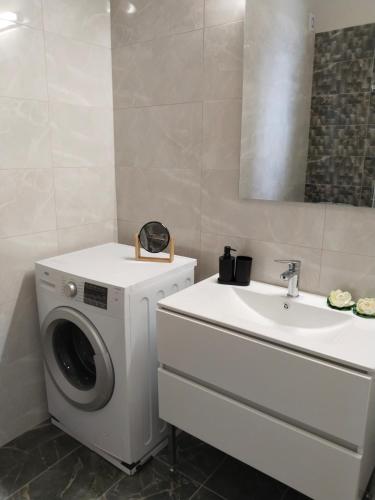 a bathroom with a washing machine and a sink at 1920 Classic in Kalamata