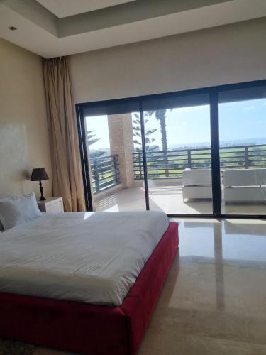 a bedroom with a large bed and a large window at Villa Mazagan de luxe 6 chambres face mer 1000m2 in El Jadida