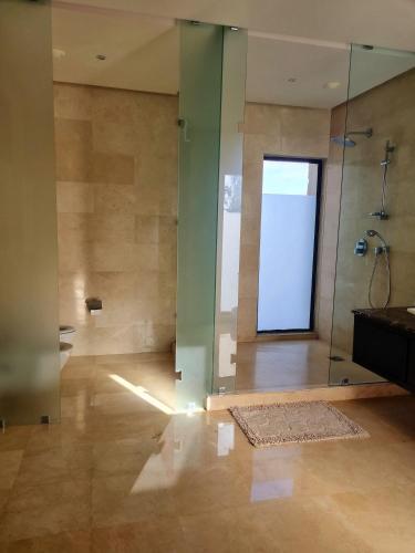a bathroom with a shower with a glass door at Villa Mazagan de luxe 6 chambres face mer 1000m2 in El Jadida