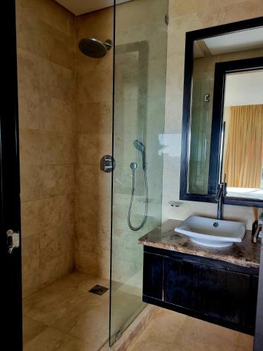 a bathroom with a sink and a glass shower at Villa Mazagan de luxe 6 chambres face mer 1000m2 in El Jadida
