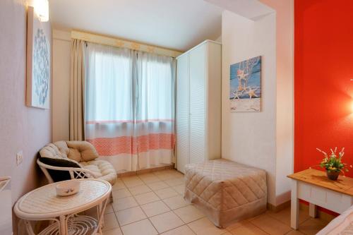 a small living room with a table and a window at Il Piccolo Giardino rooms & breakfast in Villasimius