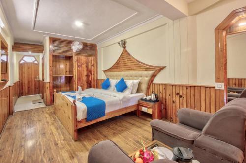 a bedroom with a large bed and a couch at Hotel Ibex in Manāli