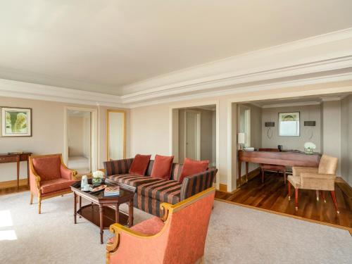 a living room with a couch and a piano at Mövenpick Hotel Al Khobar in Al Khobar